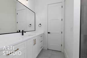Bathroom with vanity, baseboards, and tile patterned floors