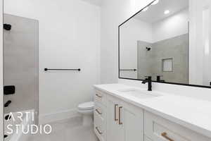 Full bathroom featuring tiled shower, toilet, vanity, baseboards, and tile patterned flooring