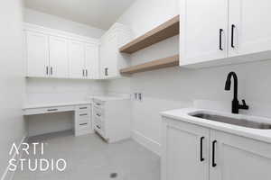 Clothes washing area with baseboards, washer hookup, and cabinet space