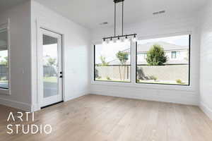 Unfurnished dining area with wood finished floors, wood walls, and baseboards