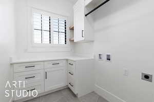 Laundry area with electric dryer hookup, cabinet space, hookup for a washing machine, light tile patterned flooring, and baseboards