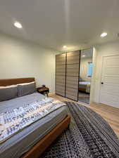 Bedroom with light wood-style flooring, recessed lighting, and baseboards