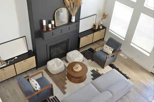 Living room featuring wood finished floors, baseboards, and a large fireplace