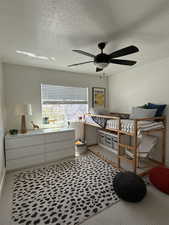 Bedroom with baseboards, a textured ceiling, and ceiling fan