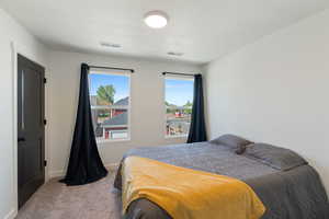 Carpeted bedroom with baseboards and a textured ceiling