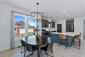 Dining area with light wood-type flooring, a chandelier, recessed lighting, and baseboards