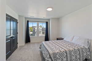 Bedroom featuring carpet floors, baseboards, and a textured ceiling