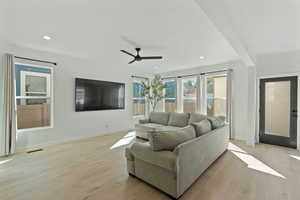 Living area featuring light wood-style flooring, a ceiling fan, recessed lighting, and baseboards