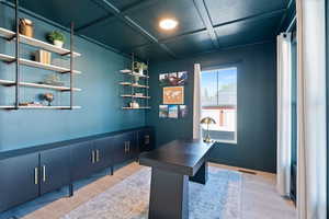 Office featuring light wood-style floors and coffered ceiling