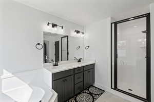 Bathroom with a stall shower, double vanity, tile patterned floors, and a bathtub