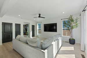 Living room with light wood-style flooring, ceiling fan, baseboards, and recessed lighting