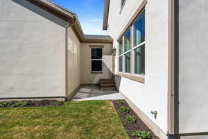 View of home's exterior featuring stucco siding and a lawn
