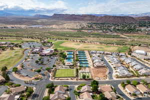 Aerial view of property's location featuring a golf course, nearby suburban area, and a water and mountain view