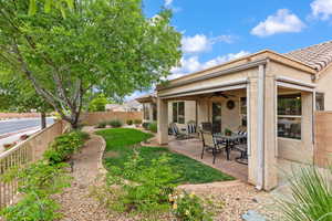 View of yard with a ceiling fan and a patio