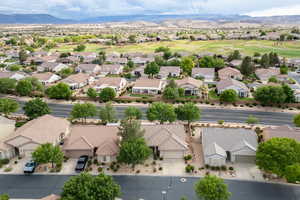 Aerial perspective of suburban area featuring a mountain backdrop and a golf course