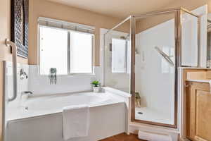Full bath featuring a stall shower and a bath