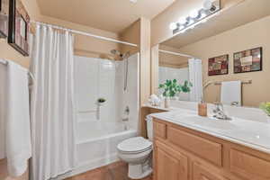 Full bathroom with tile patterned flooring, toilet, vanity, and shower / bath combination with curtain