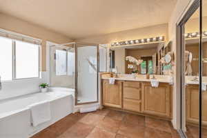 Full bath featuring a shower stall, vanity, and a garden tub