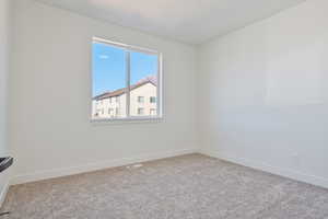 Unfurnished room featuring carpet floors and baseboards