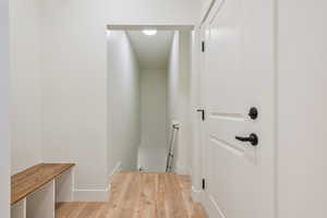 Hall featuring an upstairs landing, light wood-style floors, and baseboards