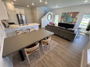 Dining area featuring light wood-style floors, stairway, plenty of natural light, recessed lighting, and baseboards