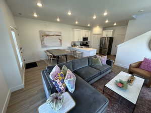 Living room with baseboards, wood finished floors, and recessed lighting