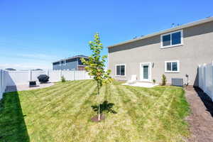 Rear view of house with central AC unit, stucco siding, and a patio