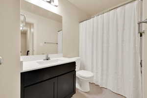 Bathroom featuring tile patterned flooring, toilet, and vanity