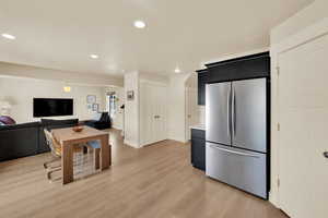 Kitchen featuring freestanding refrigerator, open floor plan, recessed lighting, light wood-style floors, and light countertops