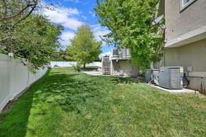 View of yard featuring central air condition unit and stairway