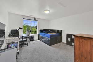 Carpeted bedroom with a desk
