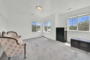 Living area featuring carpet flooring and baseboards