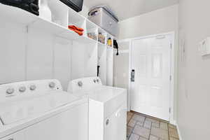 Clothes washing area with washer and clothes dryer and baseboards