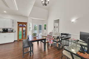 Dining area with dark wood-style floors and a chandelier