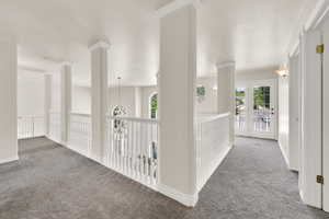 Hall with carpet flooring and a textured ceiling