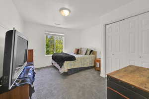 Carpeted bedroom with a closet and baseboards