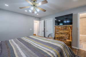 Bedroom featuring wood finished floors, ceiling fan, recessed lighting, and ensuite bathroom