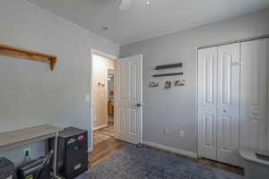Bedroom featuring wood finished floors, baseboards, a closet, and a ceiling fan