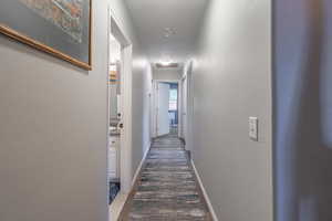 Hall with baseboards and wood finished floors