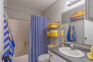 Full bathroom featuring toilet, vanity, and shower / bath combination with curtain