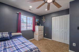 Carpeted bedroom with a closet, a ceiling fan, baseboards, and recessed lighting