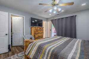 Bedroom with wood finished floors, ceiling fan, and recessed lighting