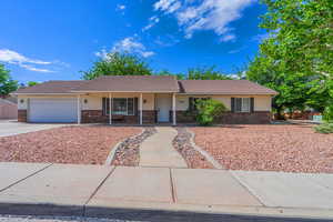 Ranch-style house featuring brick siding, a tile roof, and concrete driveway