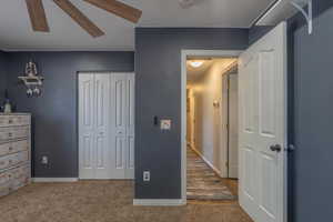 Carpeted bedroom featuring a closet, baseboards, and ceiling fan