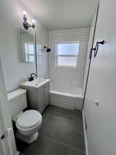 Full bathroom with tile patterned flooring, toilet,  shower combination, and vanity