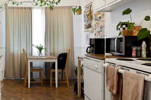Kitchen featuring white appliances and white cabinets
