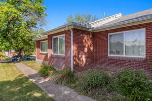 View of home's exterior featuring brick siding and a yard