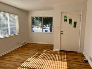 Foyer featuring healthy amount of natural light, wood finished floors, and baseboards