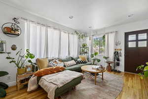 Living area with light wood-type flooring, baseboards, and recessed lighting