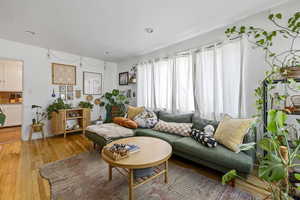 Living area with light wood-type flooring and recessed lighting